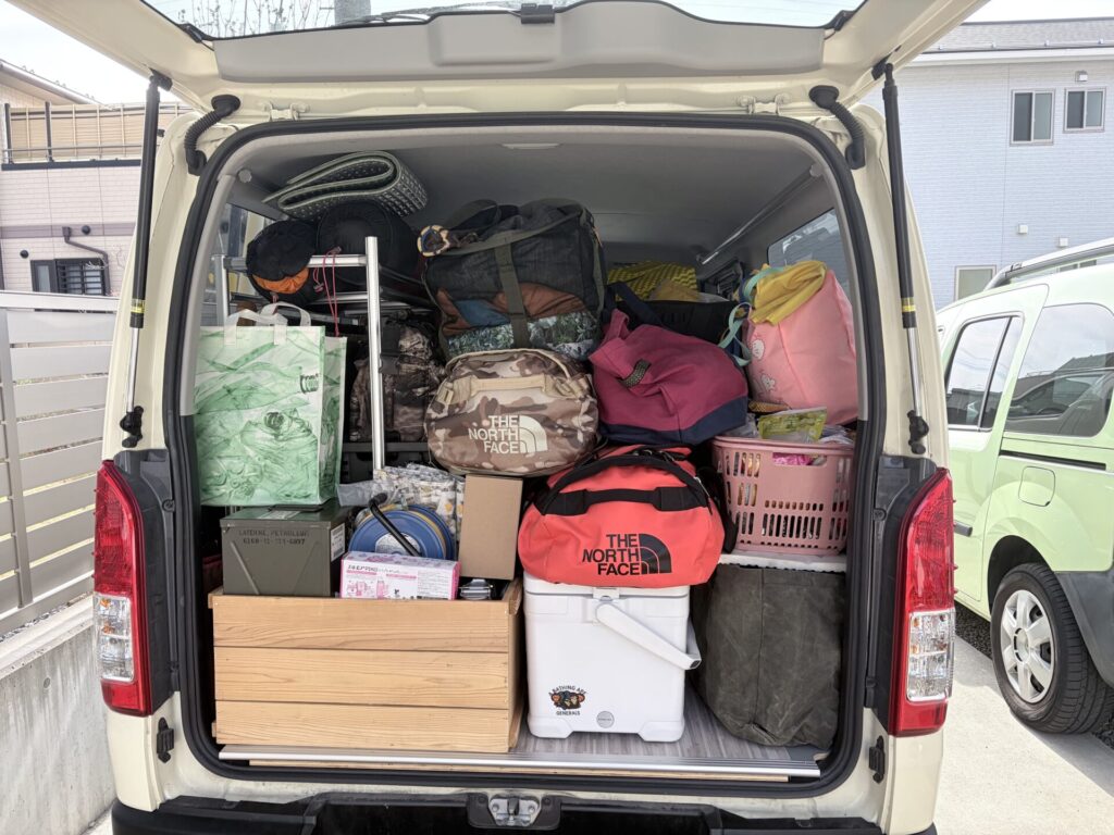 ハイエース200系の荷室にキャンプ用品とバッグを積載した様子